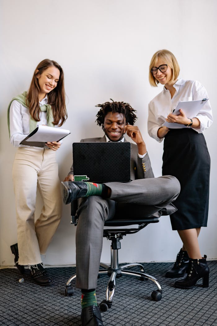 A diverse group of colleagues working together with a laptop and notes, showcasing teamwork.